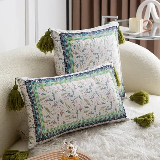 Two rectangular pillow covers with ethnic botanical print and olive green tassels in teal and navy cover set