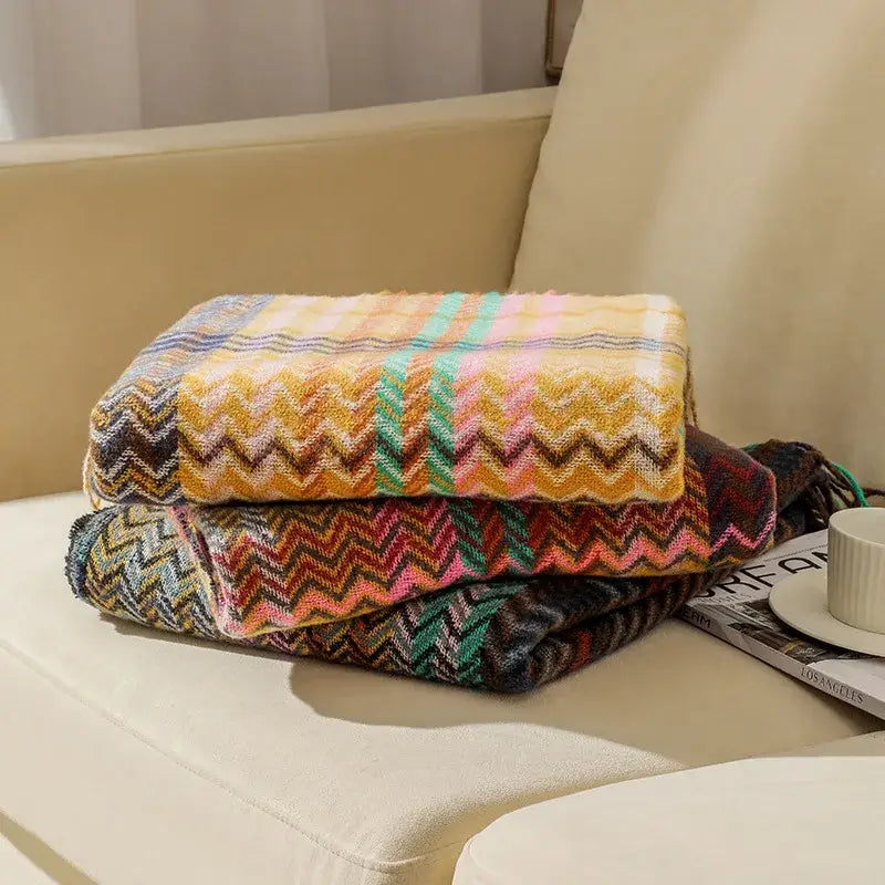 Stacked missoni wool throw blankets with bold multicolored zigzag patterns in warm tones for decorbites ethnic wave woven tassel decor