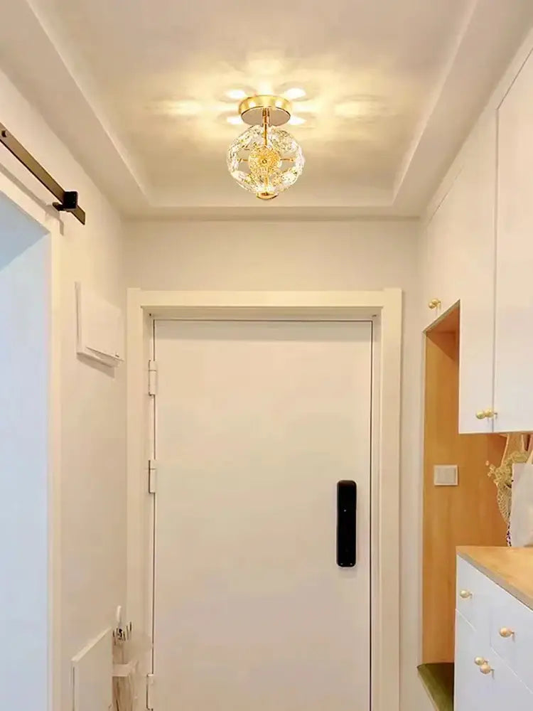European gold and polished chrome mini pendant light featuring a crystal chandelier with a faceted glass globe