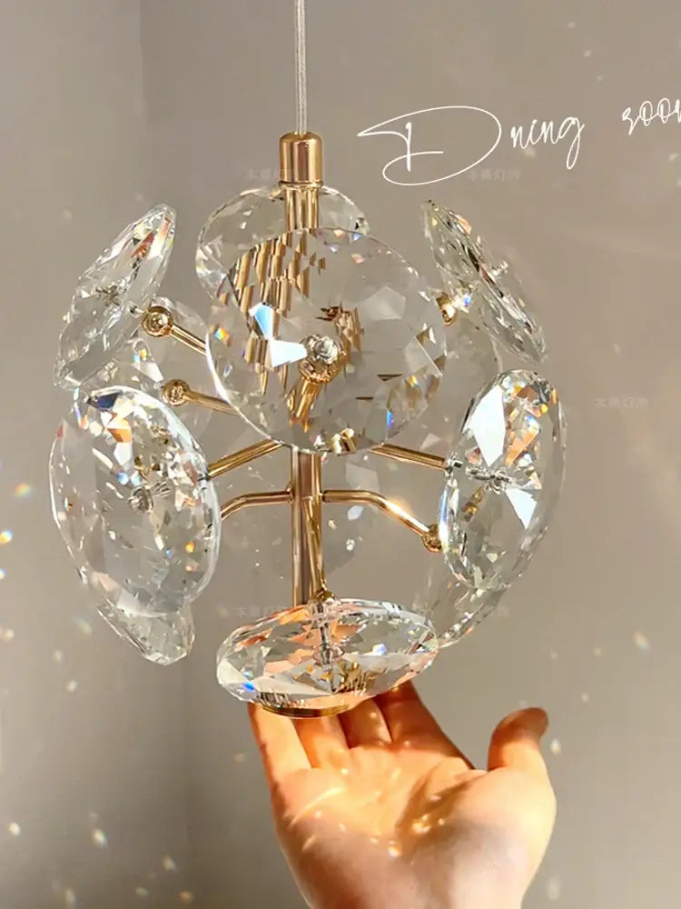 A delicate European gold and polished chrome mini pendant light featuring a spherical crystal design for dining rooms