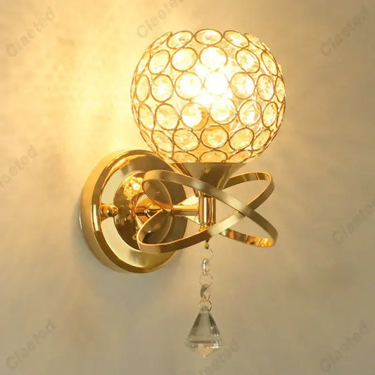 European gold crystal wall light featuring a gold-toned wall sconce with spherical globe and faceted crystal teardrop decorbites crystal wall