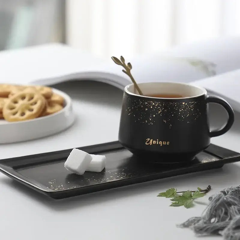 Black ceramic coffee cup with gold speckle glaze and unique inscription in a European style coffee cup set