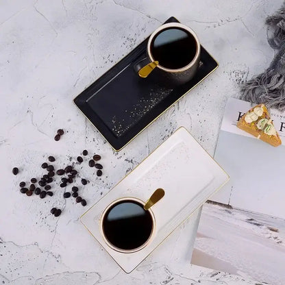 Black ceramic coffee cup with gold rim and handle on matching tray from european style ceramic coffee cup set