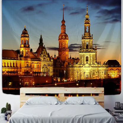 A vibrant golden European style city night scene tapestry depicting dresden architecture hangs above a wooden bed frame