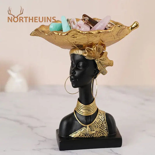 Black african resin figurine of african woman with gold accents and leaf shaped golden bowl for living room decor
