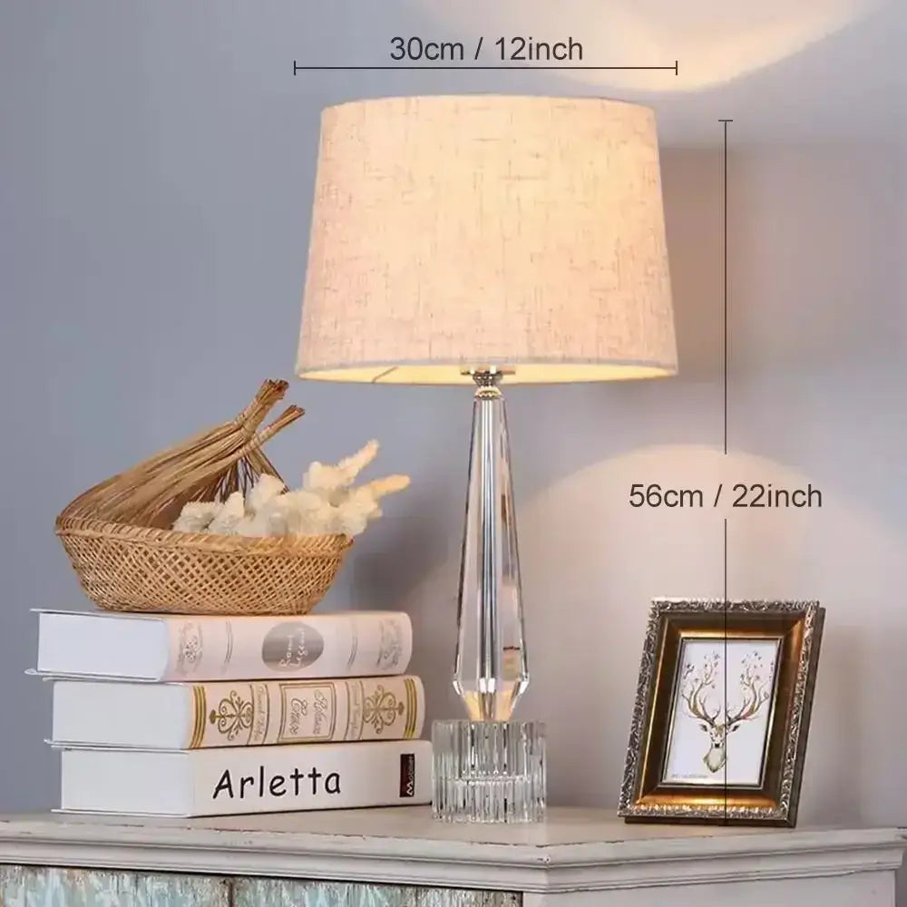 Tall elegant decorbites crystal table lamp with faceted stem, beige fabric shade, and remote control for bedroom use