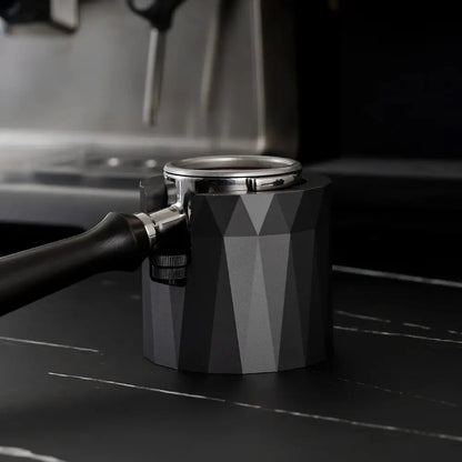 Faceted matte black metal espresso portafilter holder with geometric pattern designed as a kitchen stand for espresso portafilter