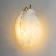 Feather gold wall light fixture with soft glowing white feather shade and gold-toned metal hook for bedroom wall light