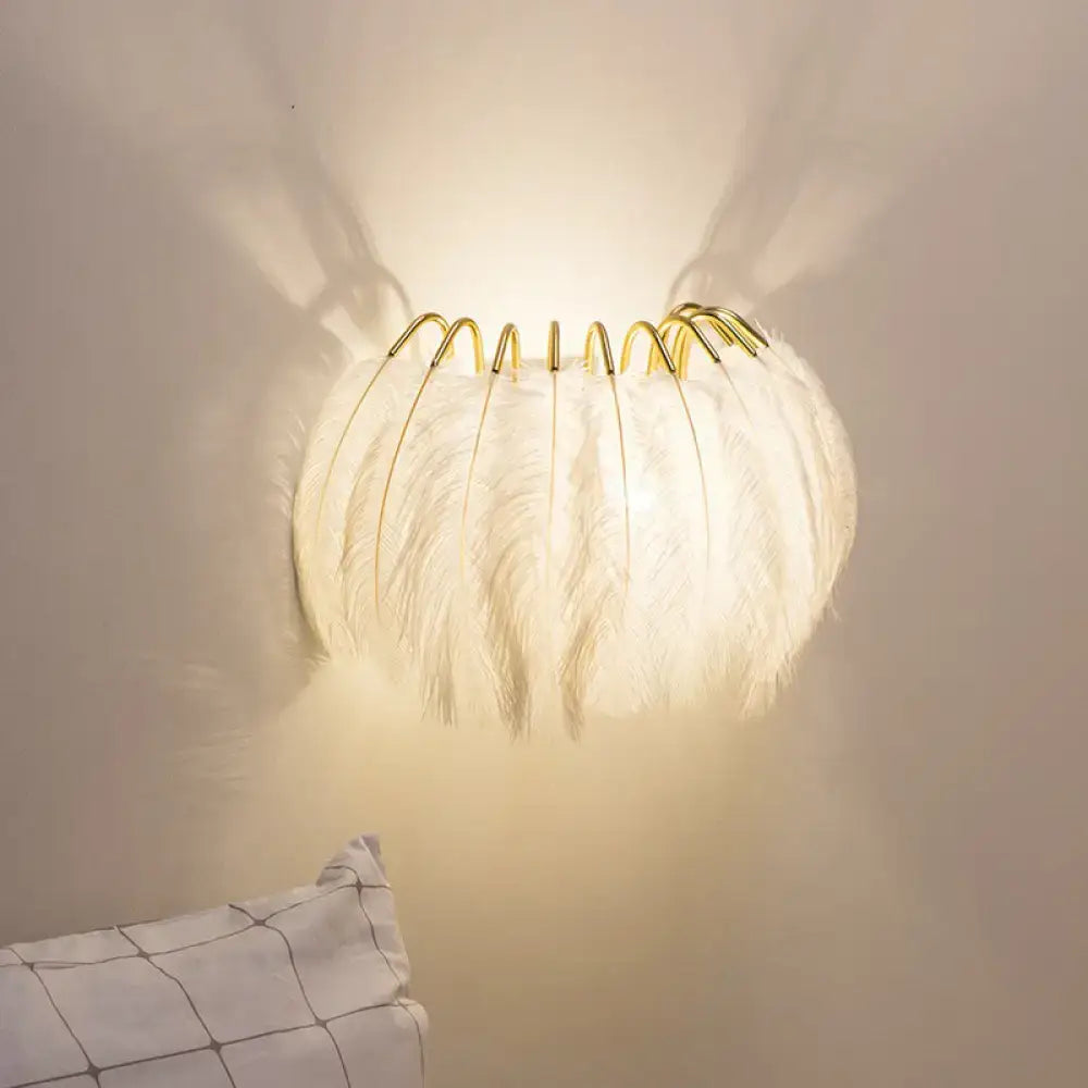 White feathered wall light fixture with gold-toned metal frame designed as a bedroom sconce wall light