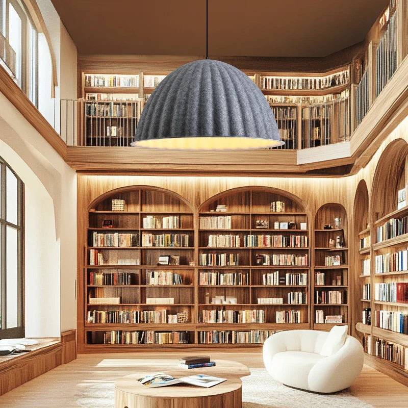 A dark gray felt pendant light acoustic dome-shaped pendant light hangs in a cozy library setting