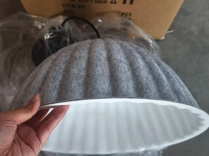 Gray ribbed felt pendant light acoustic with a white interior and fluted edges for office use