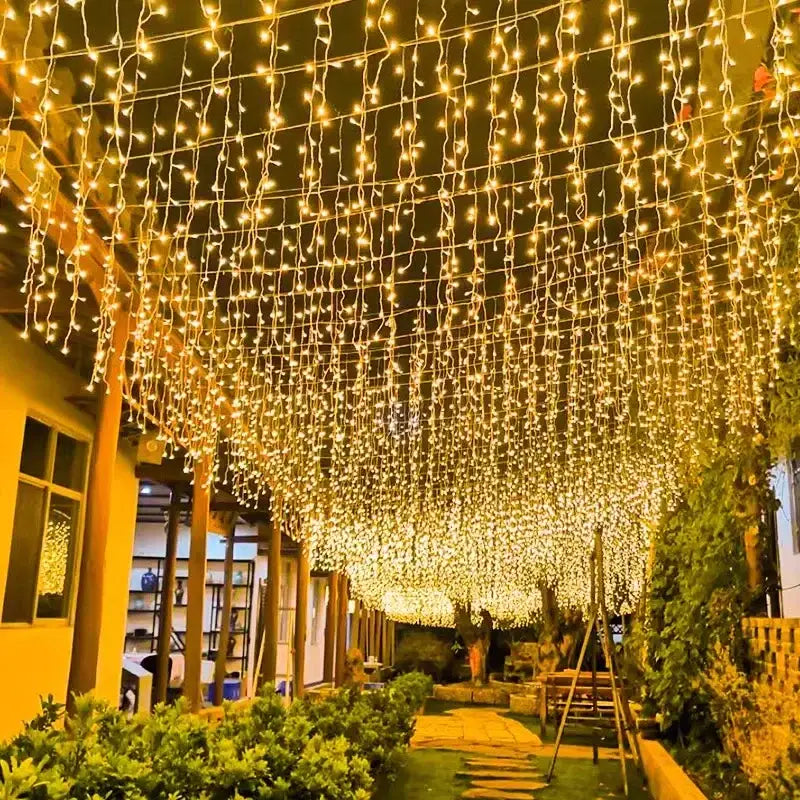 Festive golden led string lights with cascading strands creating a warm ambiance for outdoor garden decor