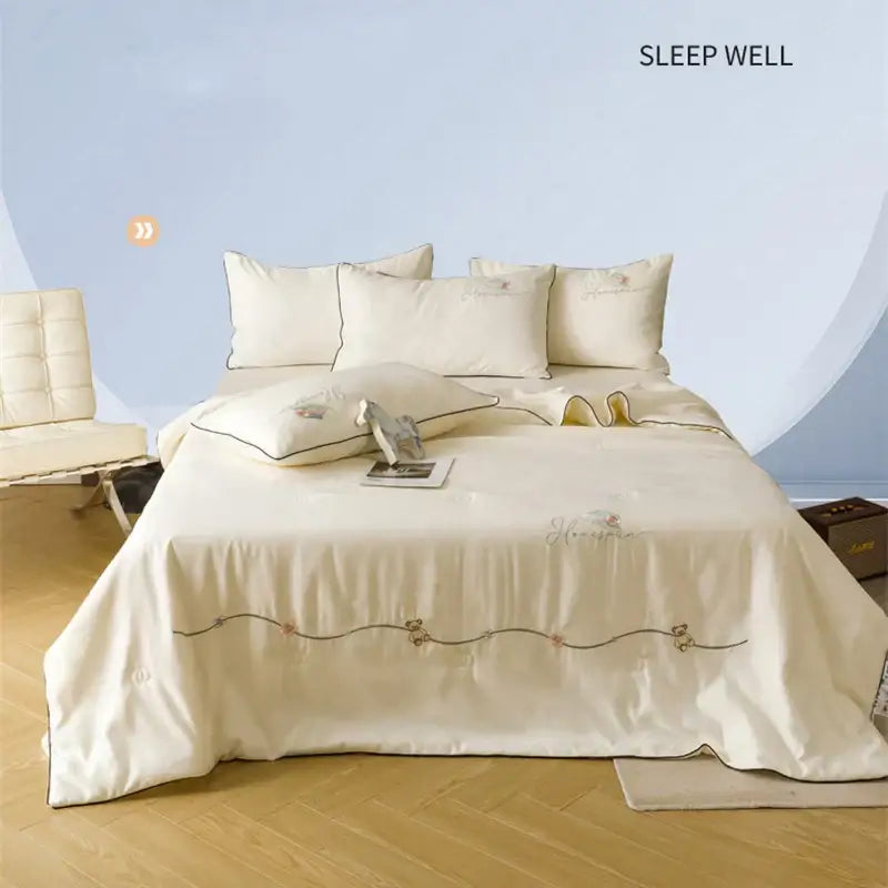 Cream-colored satin summer blanket set with delicate gold and pink embroidery for elegant bedroom decor