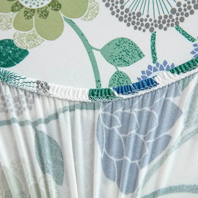 A floral blue and green elastic print chair cover with stretchy fabric and gathered edge for dining room chairs