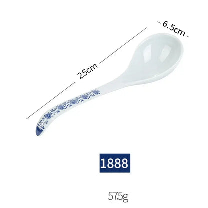 A white imitation porcelain soup spoon with blue floral handle from a floral blue and white imitation porcelain dinner set