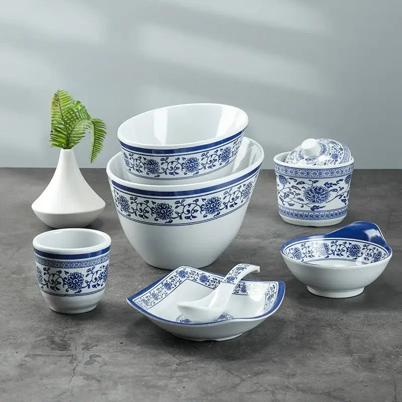 Set of white imitation porcelain dinner set with intricate blue floral patterns including a lidded container