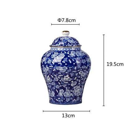 A glossy cobalt blue porcelain tea pot with white floral patterns and gold trim for kitchen storage container use