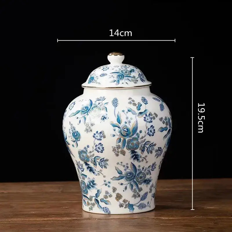 A white porcelain tea pot storage container with intricate blue floral patterns and gold trim for kitchen use