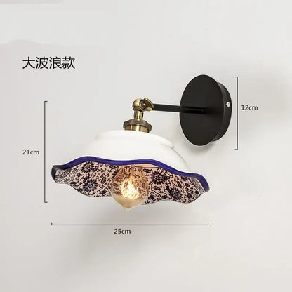 A white ceramic wall lamp with a scalloped black floral glass shade and purple rim decorbites blue white porcelain