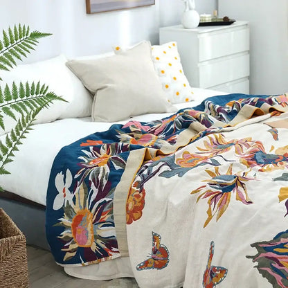 A vibrant floral embroidered cream and navy blue cozy gauze cotton throw with colorful butterfly accents for decorbites cozy gauze decor