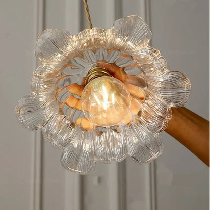 Floral green and champagne glass pendant light with clear flower-shaped glass and warm glowing bulb for dining room