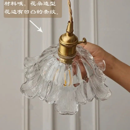 Clear glass pendant light with flower-shaped ribbed design and brass hardware for dining room use