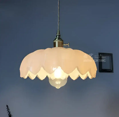 Vintage-style glass pendant light with soft peach scalloped shade and golden brass hardware for living room lighting