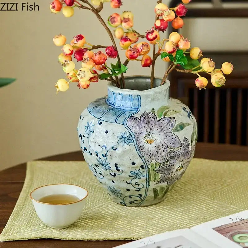 Floral hand painted decorbites ceramic vase with textured off-white glaze and blue purple patterns with artificial flowers