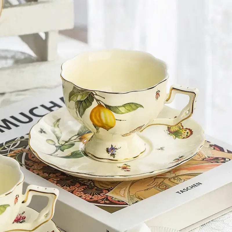 Cream-colored porcelain tea set with gold trim and hand-painted lemon design for elegant dining room use
