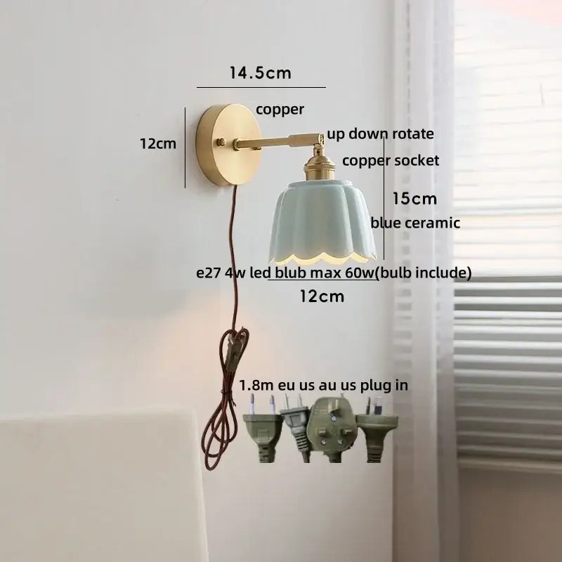 Delicate blue ceramic wall light fixture with scalloped edge mounted on polished copper arm for bedroom use