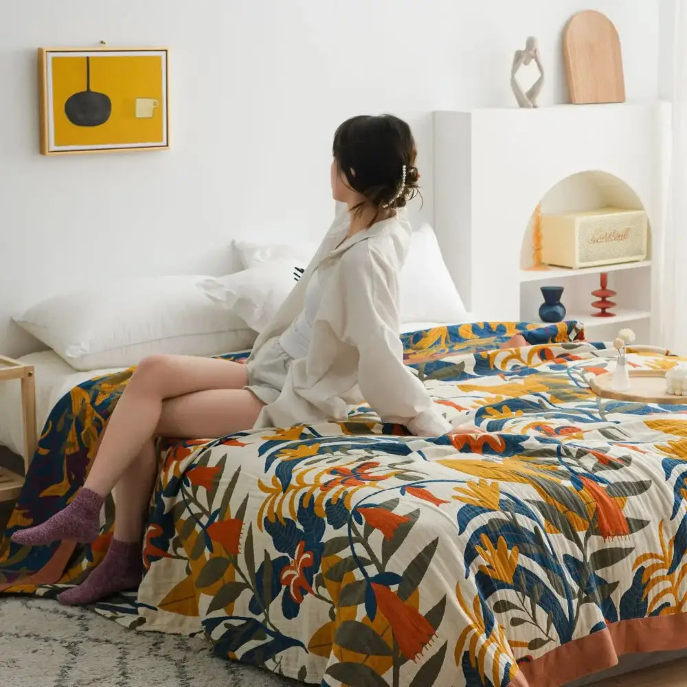A vibrant floral mustard and white cotton throw blanket with bold orange blue and green botanical designs for decorbites cotton throw