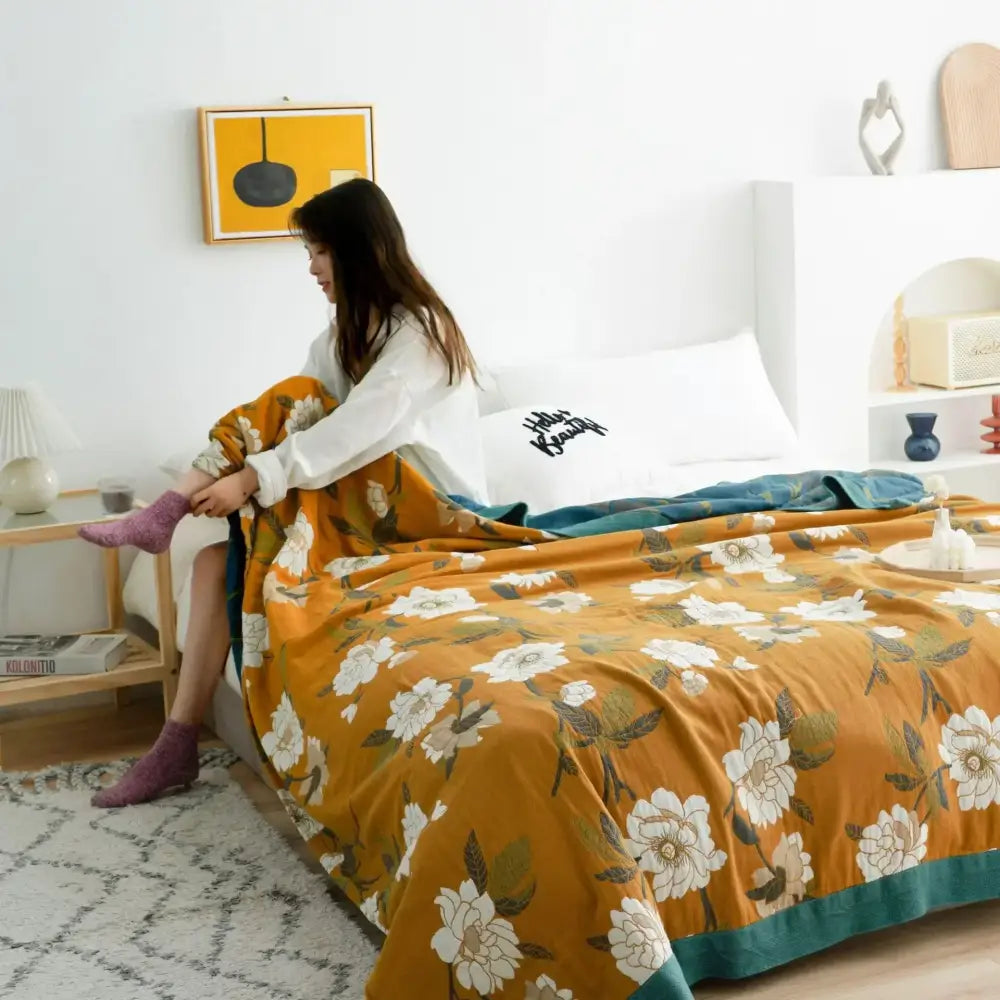 Floral mustard and white cotton throw blanket with warm orange blossoms green leaves and teal border decorbites cotton throw