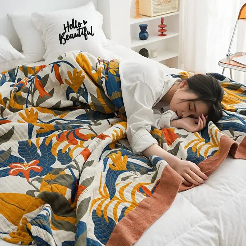 Cozy multicolored floral decorbites cotton summer throw blanket with bold orange blue and green leaves on cream background