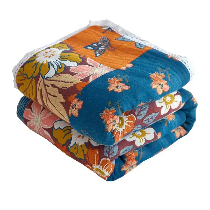 A cozy floral patchwork sofa cover in breathable cotton gauze with orange teal maroon tones and white lace trim decorbites breathable cotton