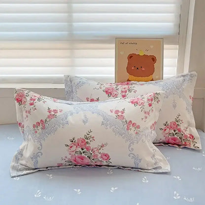 Cream-colored pillowcases with pink rose floral patterns and light blue ornate borders in decorbites cotton printed bedding set