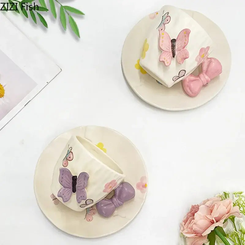 Cream-colored ceramic cup and saucer set with pink and purple butterfly appliqués and decorbites bowknot ceramic accents