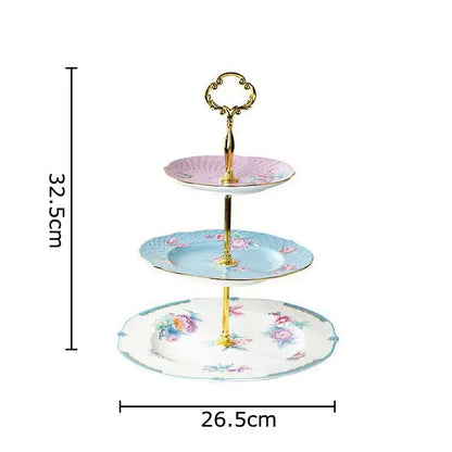Three-tiered porcelain dessert stand with floral patterns and gold-toned handle complementing the floral pink and purple coffee mug set