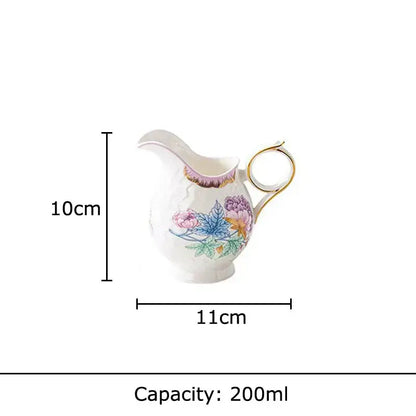 A delicate white porcelain creamer with gold trim and hand-painted floral motifs in a floral pink and purple coffee mug set