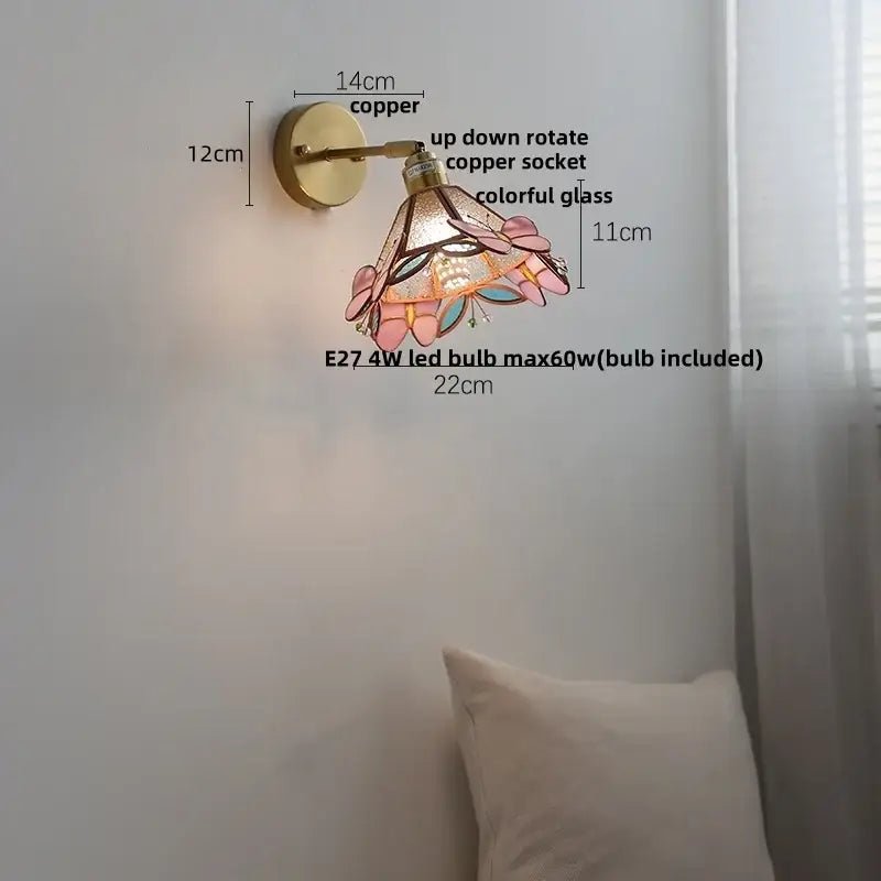 A decorative copper wall light with decorbites butterfly glass stained shade featuring pink and teal floral patterns