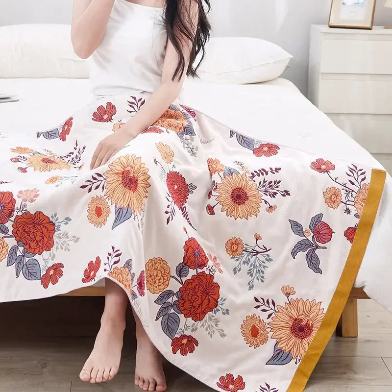 A flowing white maxi skirt with vibrant orange and red floral patterns and golden trim, complementary to decorbites cotton gauze bath towel bathroom decor