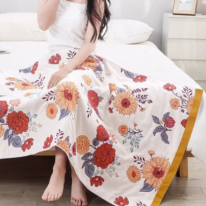 A flowing white maxi skirt with vibrant orange and red floral patterns and golden trim, complementary to decorbites cotton gauze bath towel bathroom decor