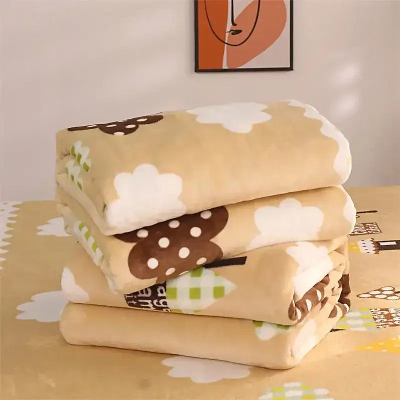 Stacked beige plush blankets with brown polka-dotted tree and white cloud patterns in decorbites coral fleece flannel