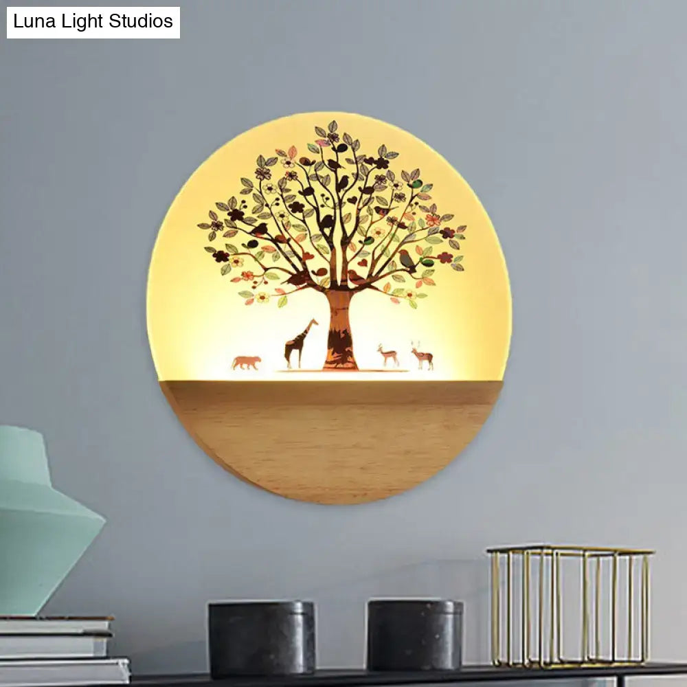 Circular wall light with warm yellow glow featuring animal flowering tree design on acrylic shade and wooden base