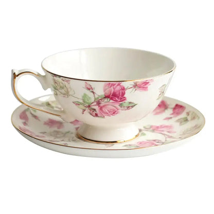 A delicate white bone china tea cup set with pink rose blossoms and gold rim for elegant dining room drinkware