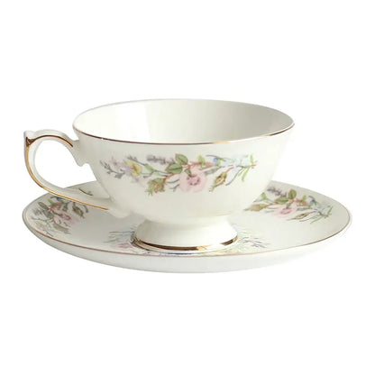 A delicate white bone china tea set teacup with gold rim and pink floral patterns enhances tea drinking experience