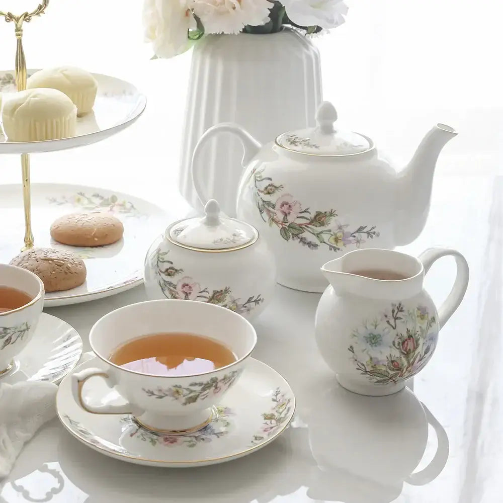 White bone china tea set featuring a white porcelain teapot with floral patterns and gold-trimmed lid for tea-drinking experience