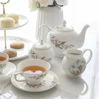 White porcelain teapot with delicate floral patterns and gold-trimmed lid from bone tea set for tea-drinking experience