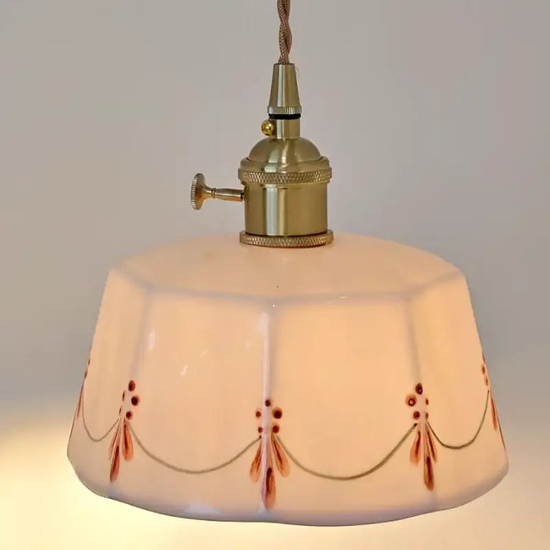 Vintage-style wall light with cream ceramic faceted shade and brown floral pattern in brass led wall sconce design