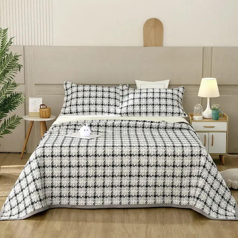 Black and white houndstooth patterned quilt with textured weave draped over bed in decorbites cotton double bedspread set