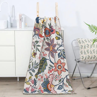 A cozy cream cotton gauze floral bath towel with vibrant pink orange and purple blossoms by Decorbites